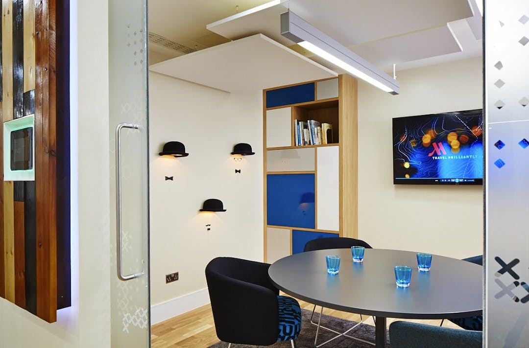 Modern meeting room at London Marriott Kensington with round table for collaboration.