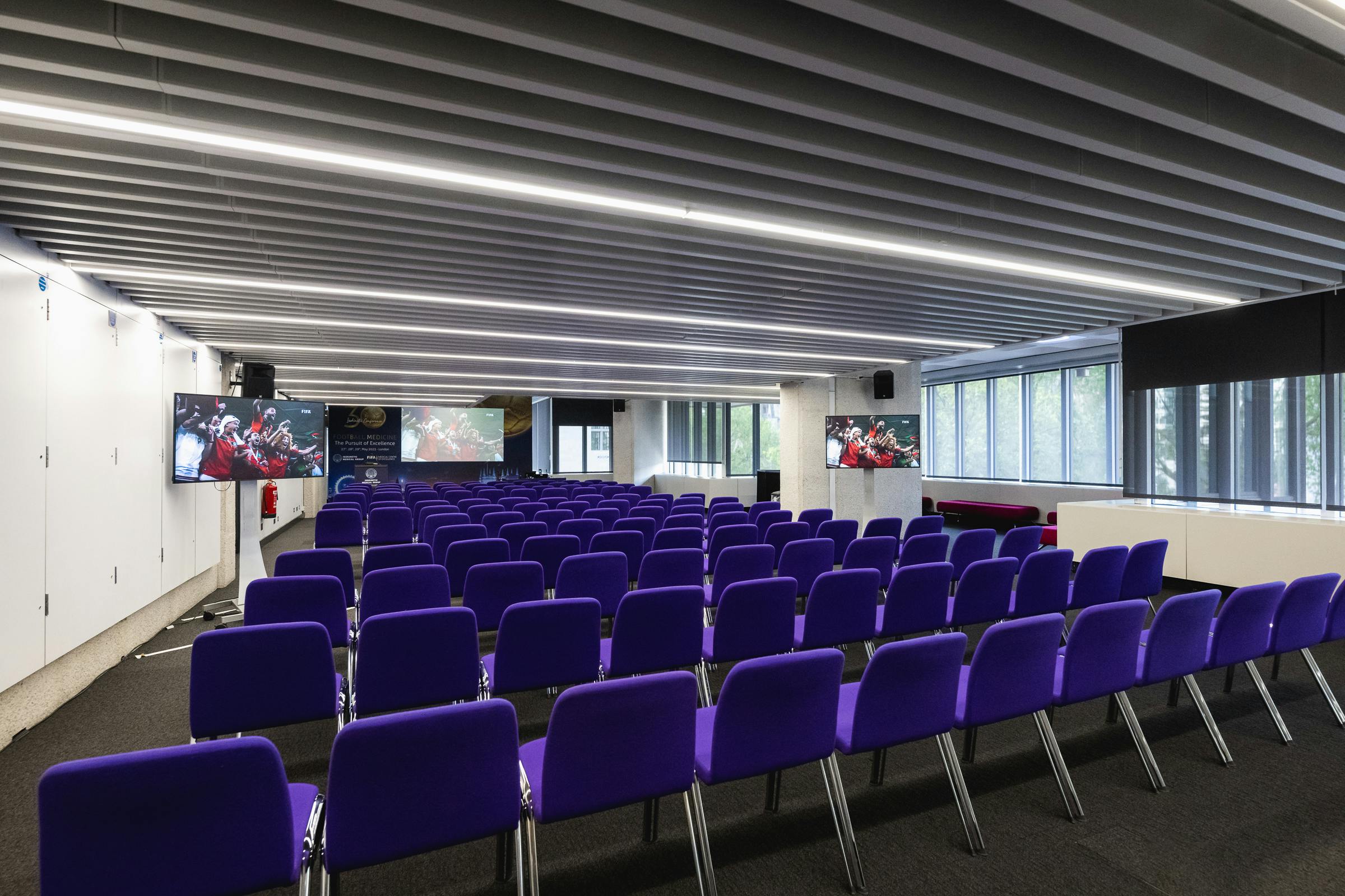 Modern conference room with purple chairs at QEII Centre for events and workshops.