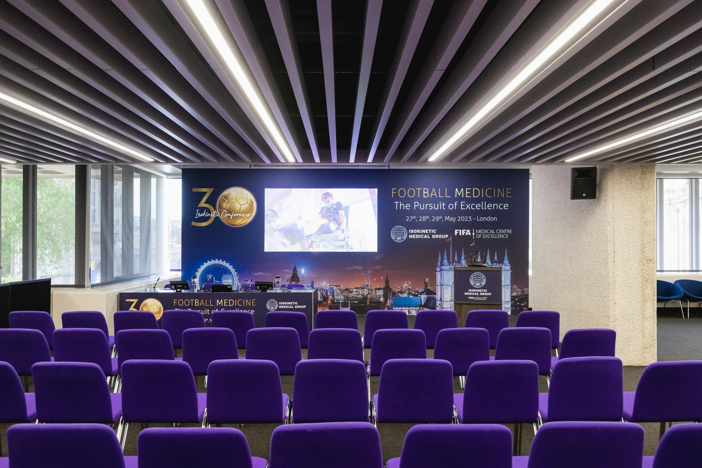 Olivier at QEII Centre, purple chairs for Football Medicine conference event.