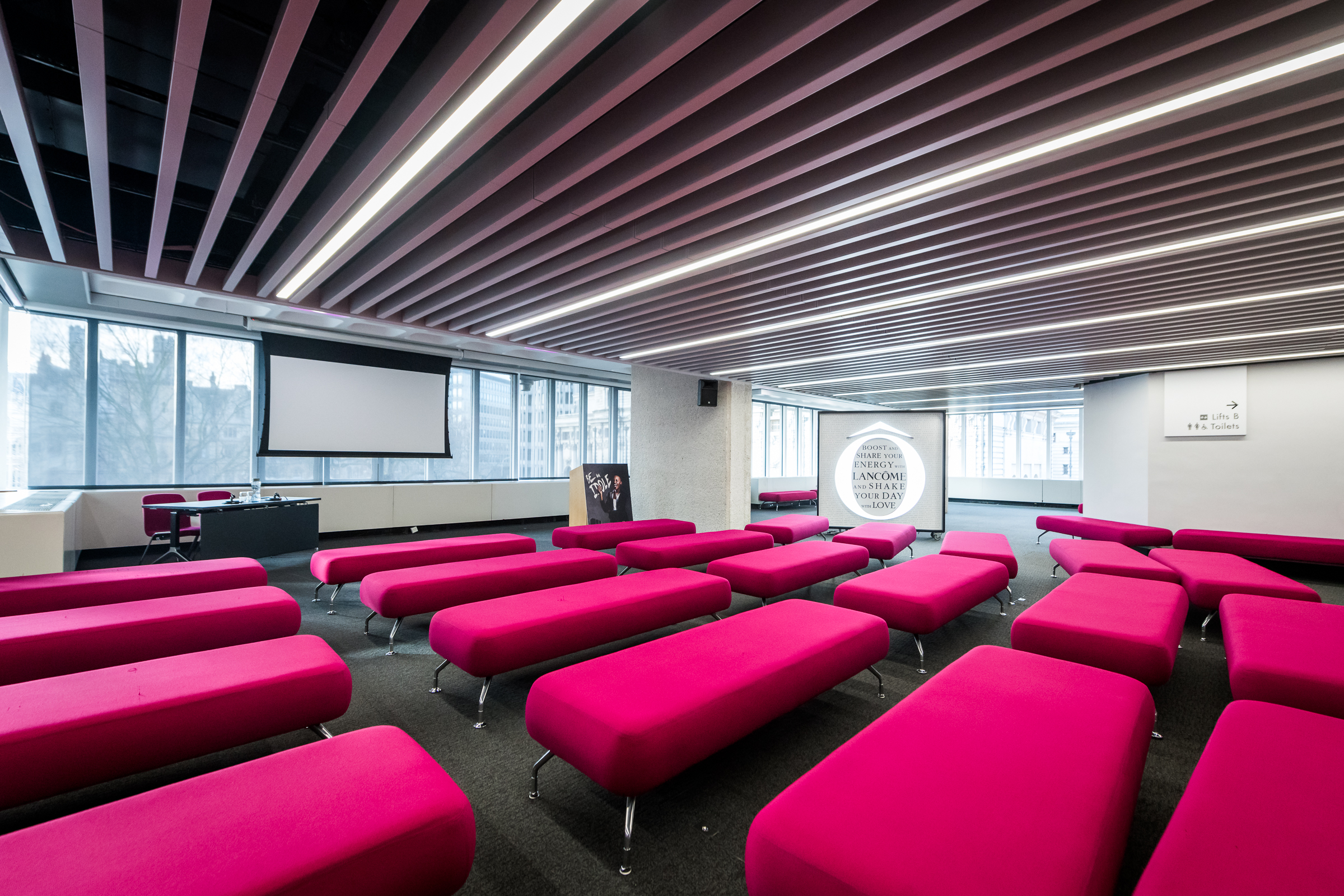Olivier in vibrant pink seating at QEII Centre, ideal for workshops and presentations. - Banner