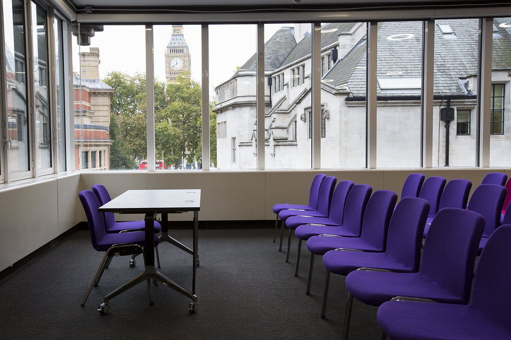 Modern meeting space in QEII Centre with purple chairs, ideal for workshops and presentations.