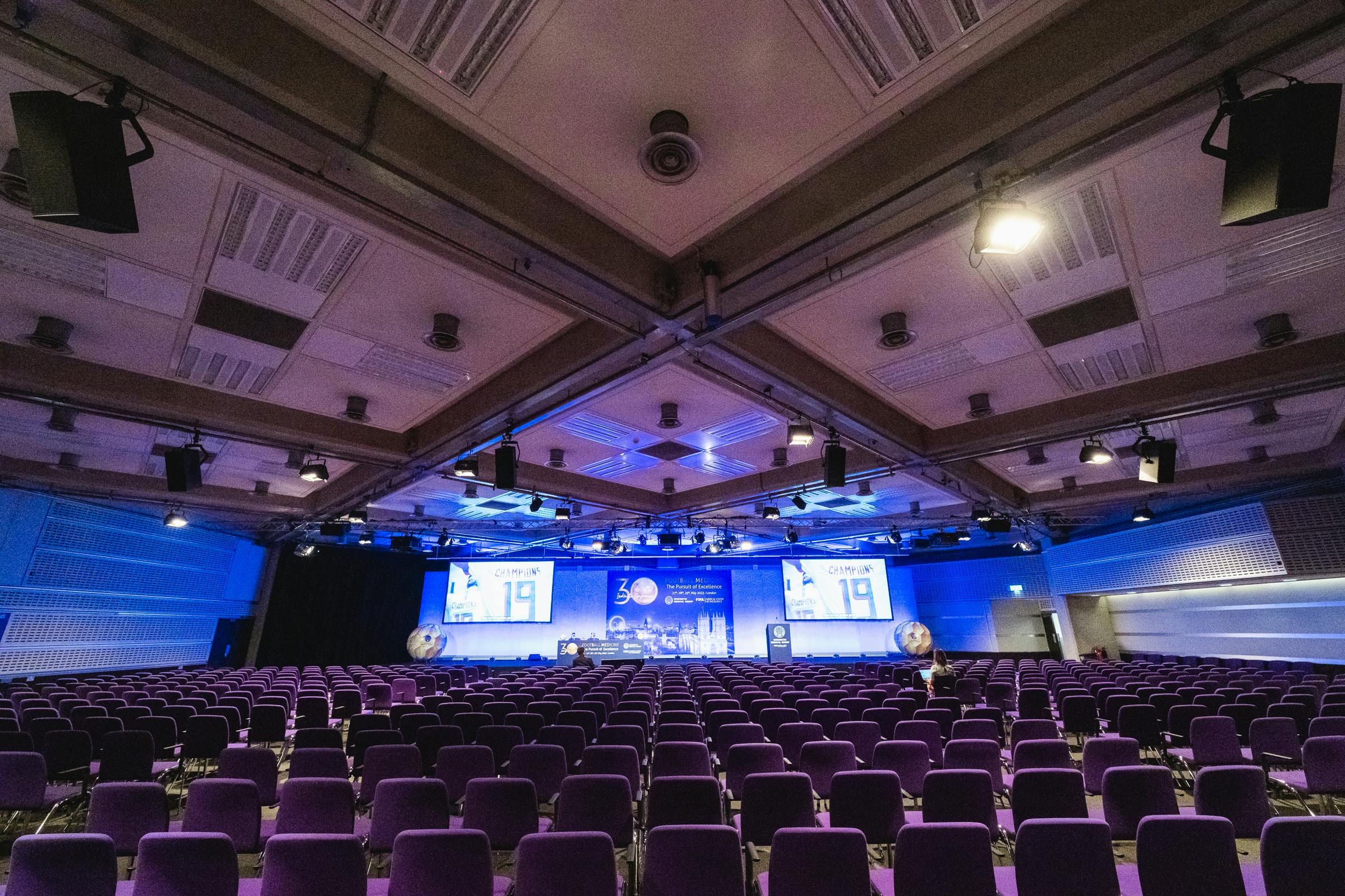 Spacious conference hall with purple chairs for professional events at QEII Centre.