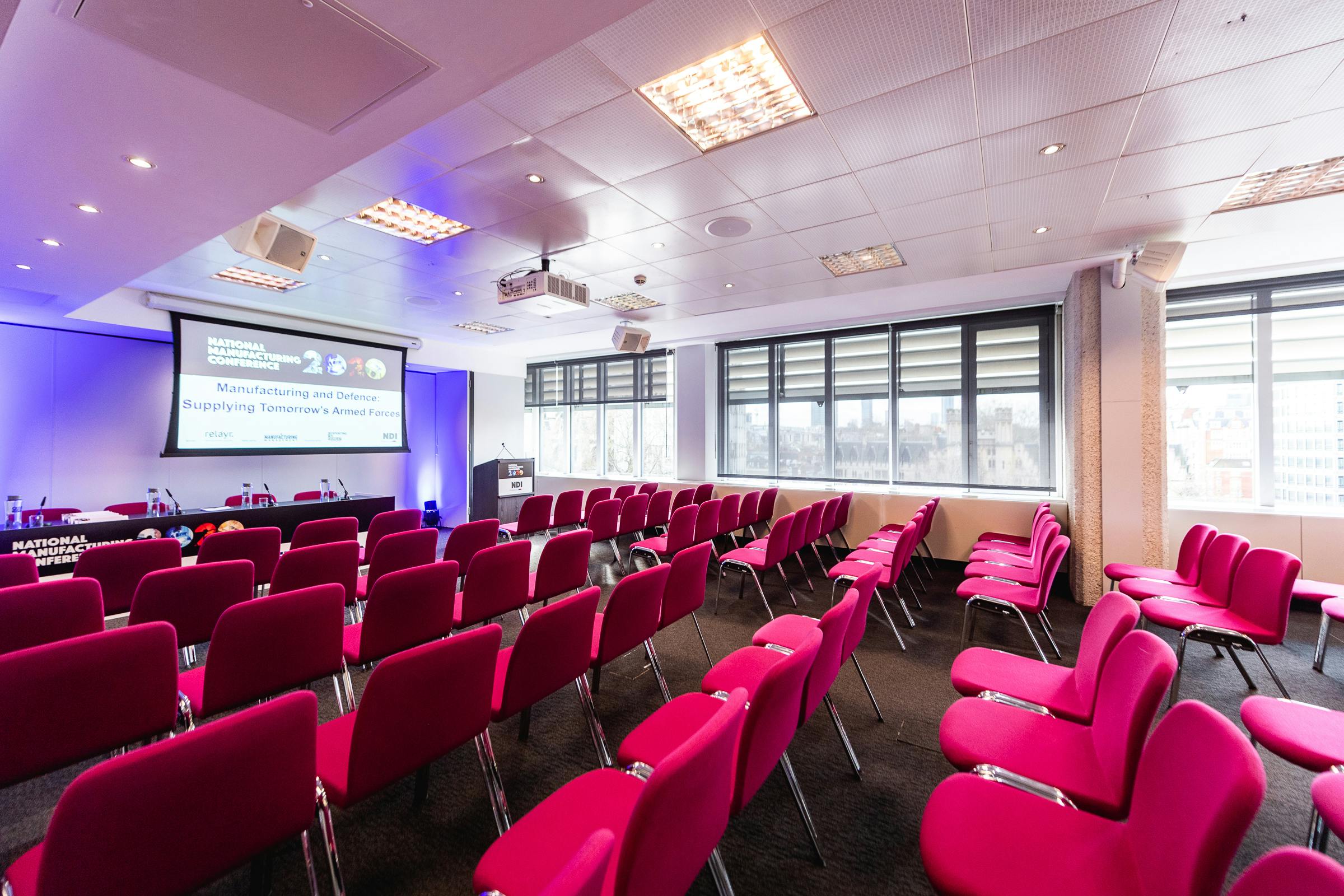 Modern conference room with pink chairs for events at QEII Centre, bright and inviting.