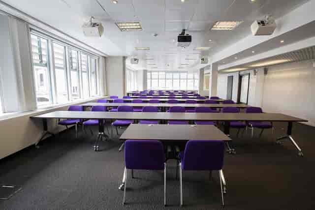 Versatile meeting space in QEII Centre with purple chairs for workshops and training.