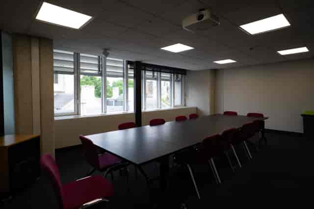 Well-lit meeting room with large table, ideal for corporate events and brainstorming sessions.
