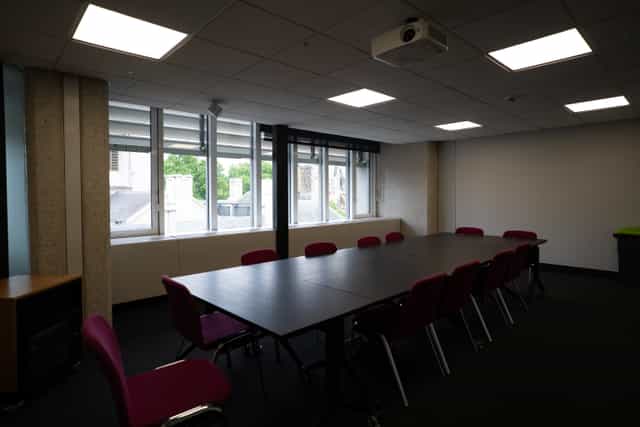 Well-lit meeting room with large table, ideal for corporate events and brainstorming sessions.