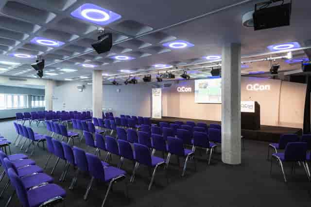 Modern conference room in QEII Centre with purple chairs for a tech event.