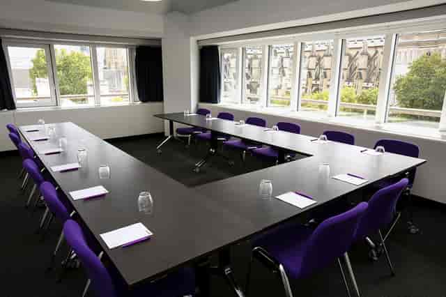 Hawking in a U-shaped meeting room with purple chairs, ideal for workshops and discussions.