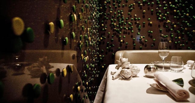 Elegant dining space at Salon Privé, featuring artistic wall design for exclusive events.