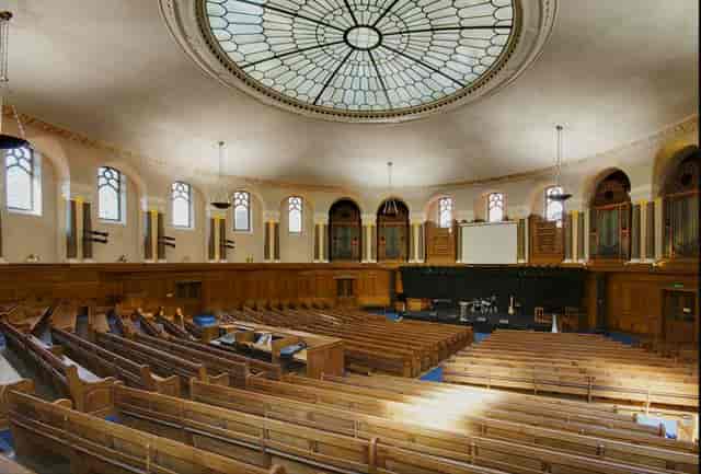Emmanuel Centre auditorium with fixed bench seating for corporate lectures and keynote sessions.