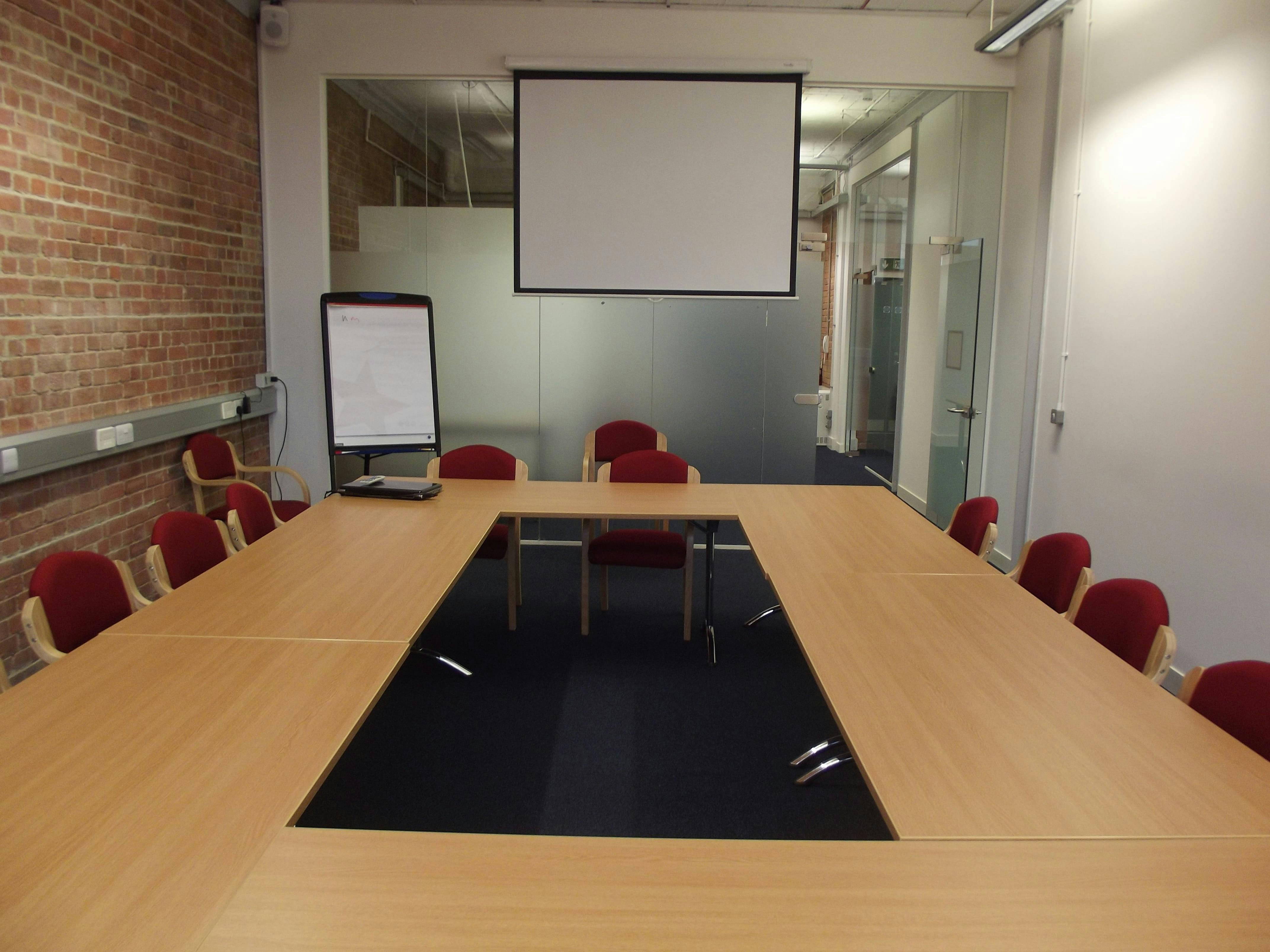 Meeting room 2 in Studio 22 with projector screen for collaborative meetings.
