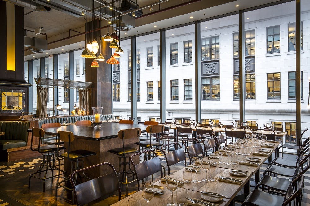 Modern event space with large windows at Bread Street Kitchen, ideal for gatherings.
