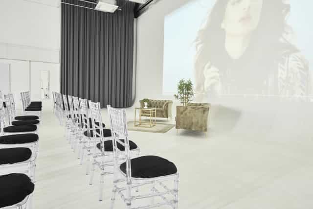 Sleek event space with white chairs, ideal for presentations and gatherings at S2 Royal Arsenal.