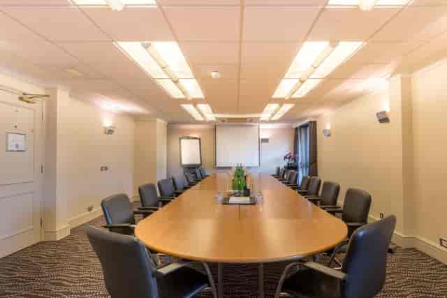 Convair Suite meeting room at Thistle London Heathrow, featuring an oval table and flip chart.
