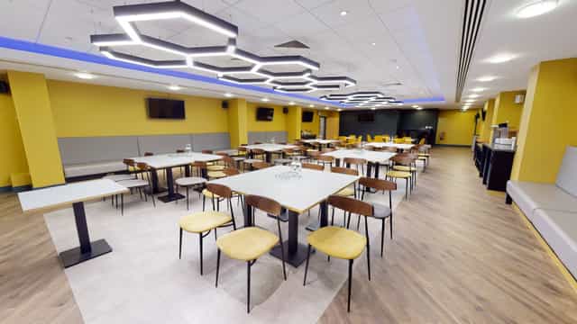 Modern event space in Molineux Stadium with yellow walls, ideal for meetings and gatherings.