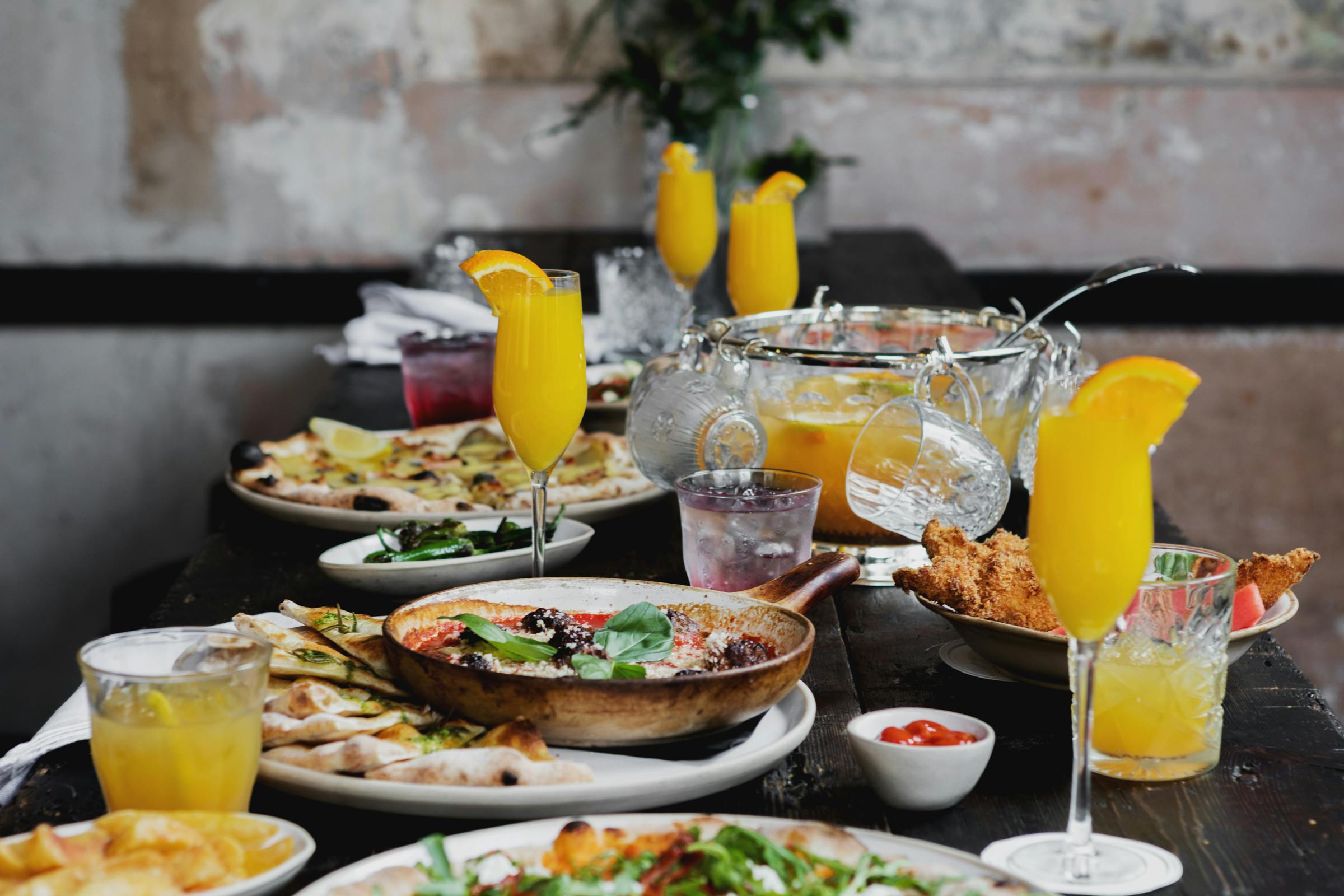 Brunch table setup with vibrant dishes and mimosas at Martello Hall venue.