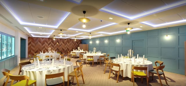 Elegant Great Hall with round tables, ideal for corporate events and celebrations.