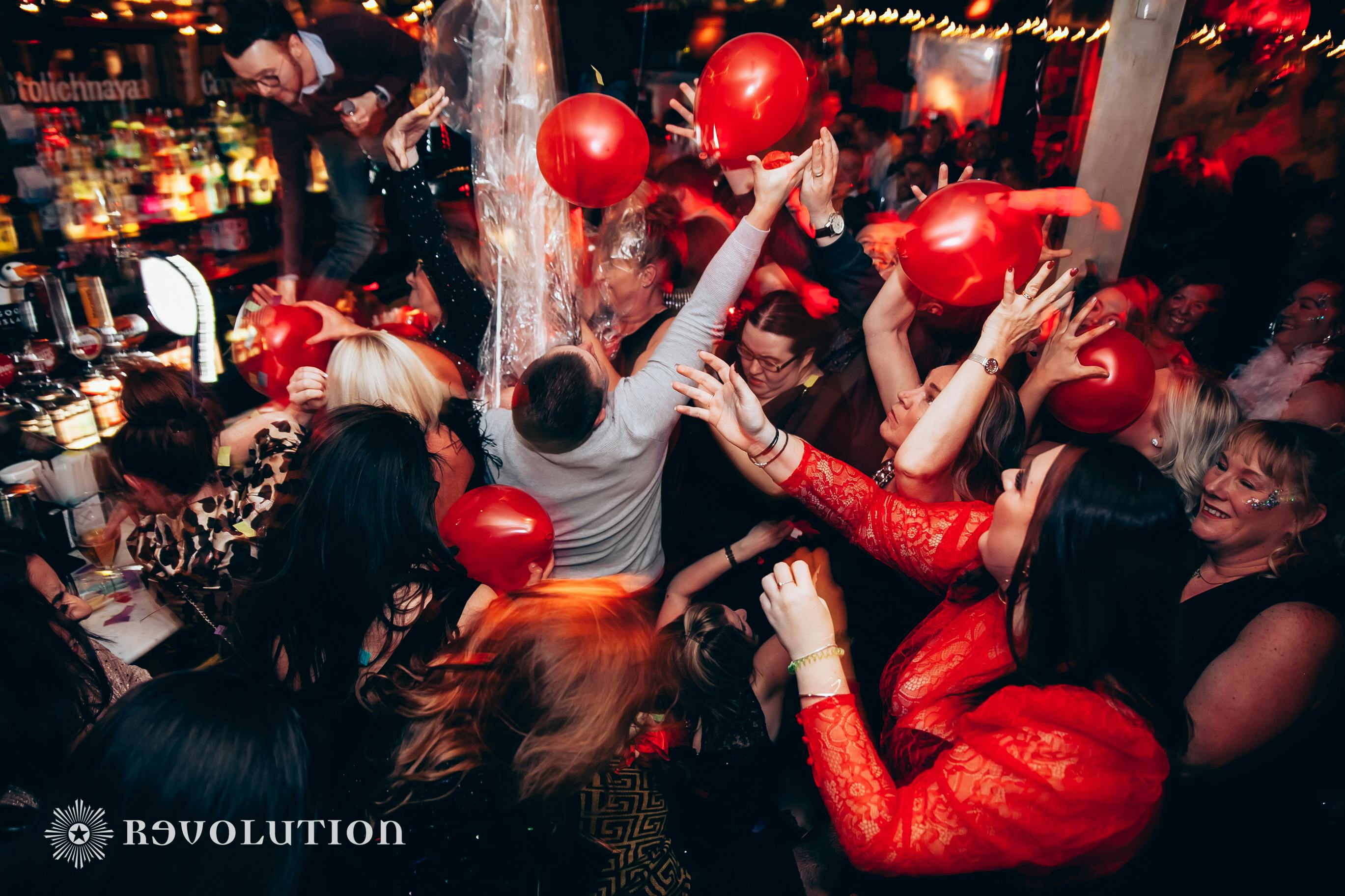 Vibrant event at The Loft, Manchester with red balloons and lively crowd celebration.
