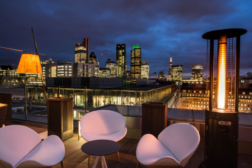 Stylish rooftop venue with city skyline, ideal for upscale events and gatherings. - Banner