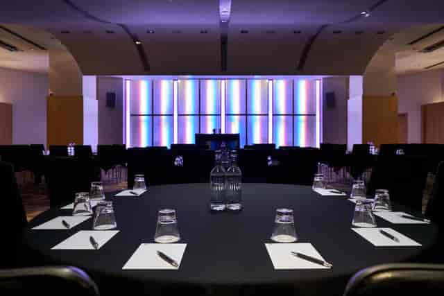 Modern meeting space at The Arena, Cumberland Hotel with round table setup for events.