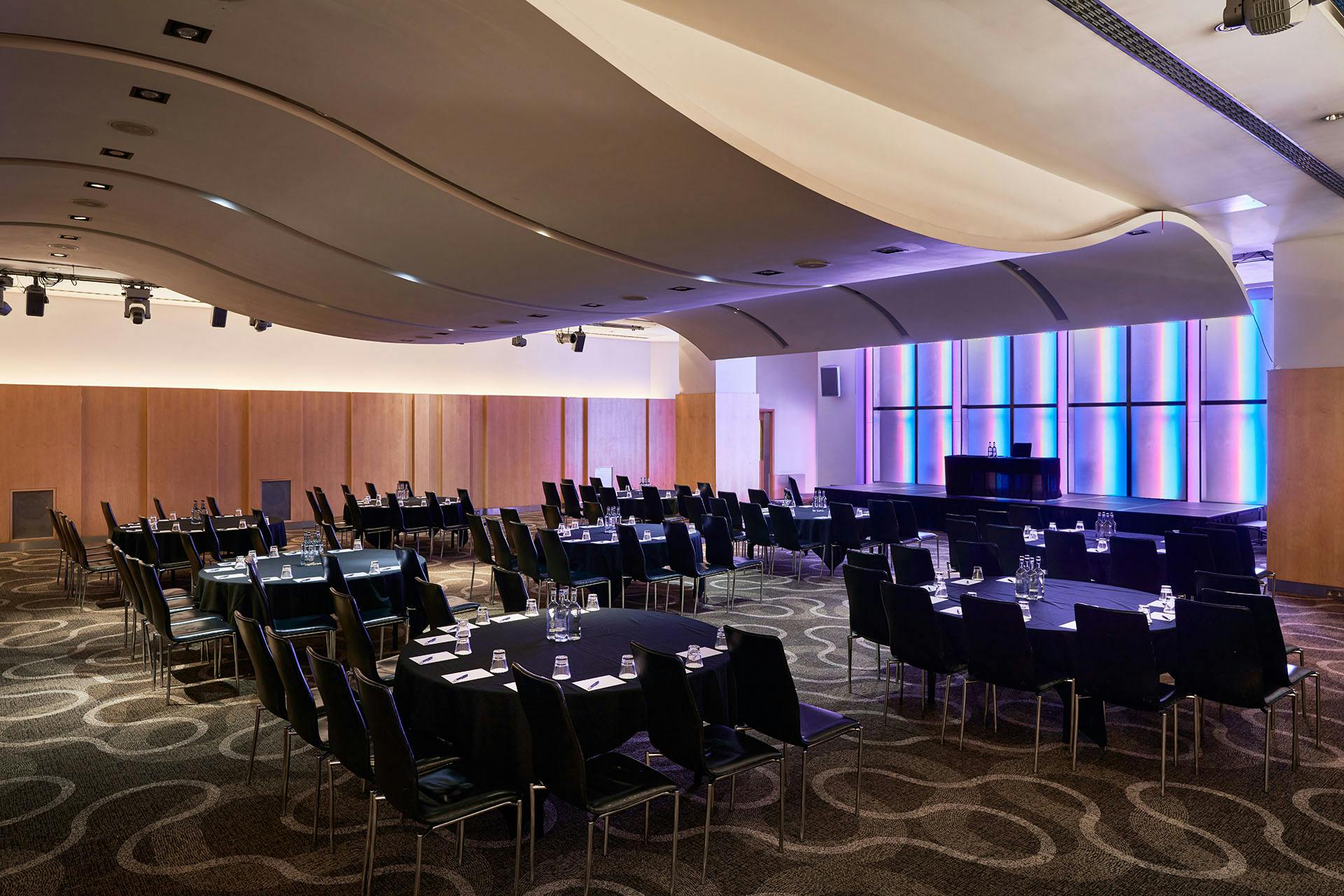 Versatile event space at The Cumberland Hotel with sleek curved ceiling for conferences.