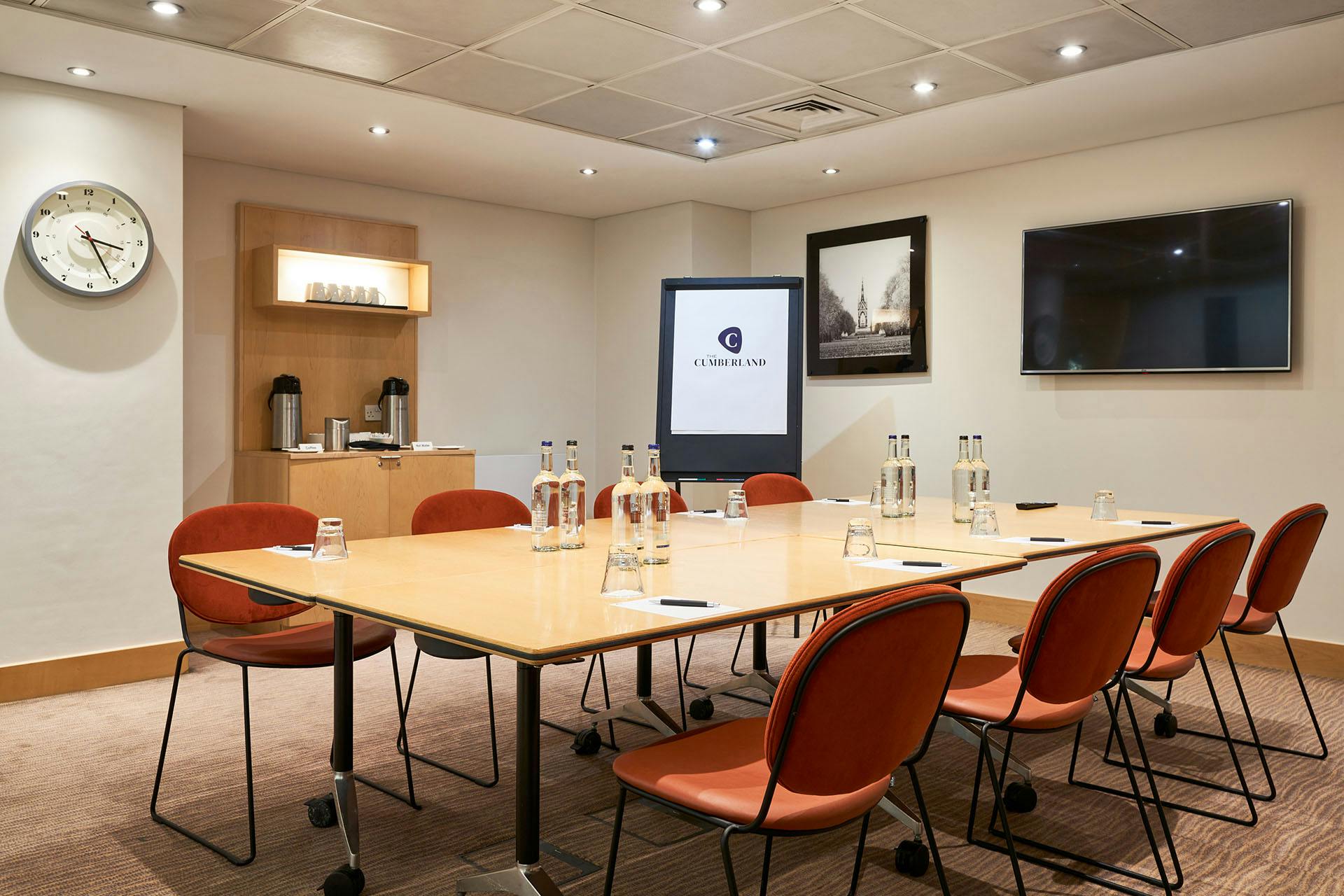 Meeting room at The Cumberland Hotel with large table and presentation screen.