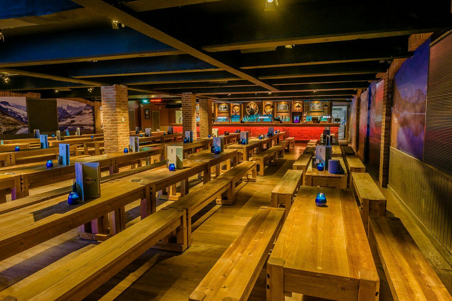 Spacious Bierkeller venue with wooden tables, ideal for gatherings and events.