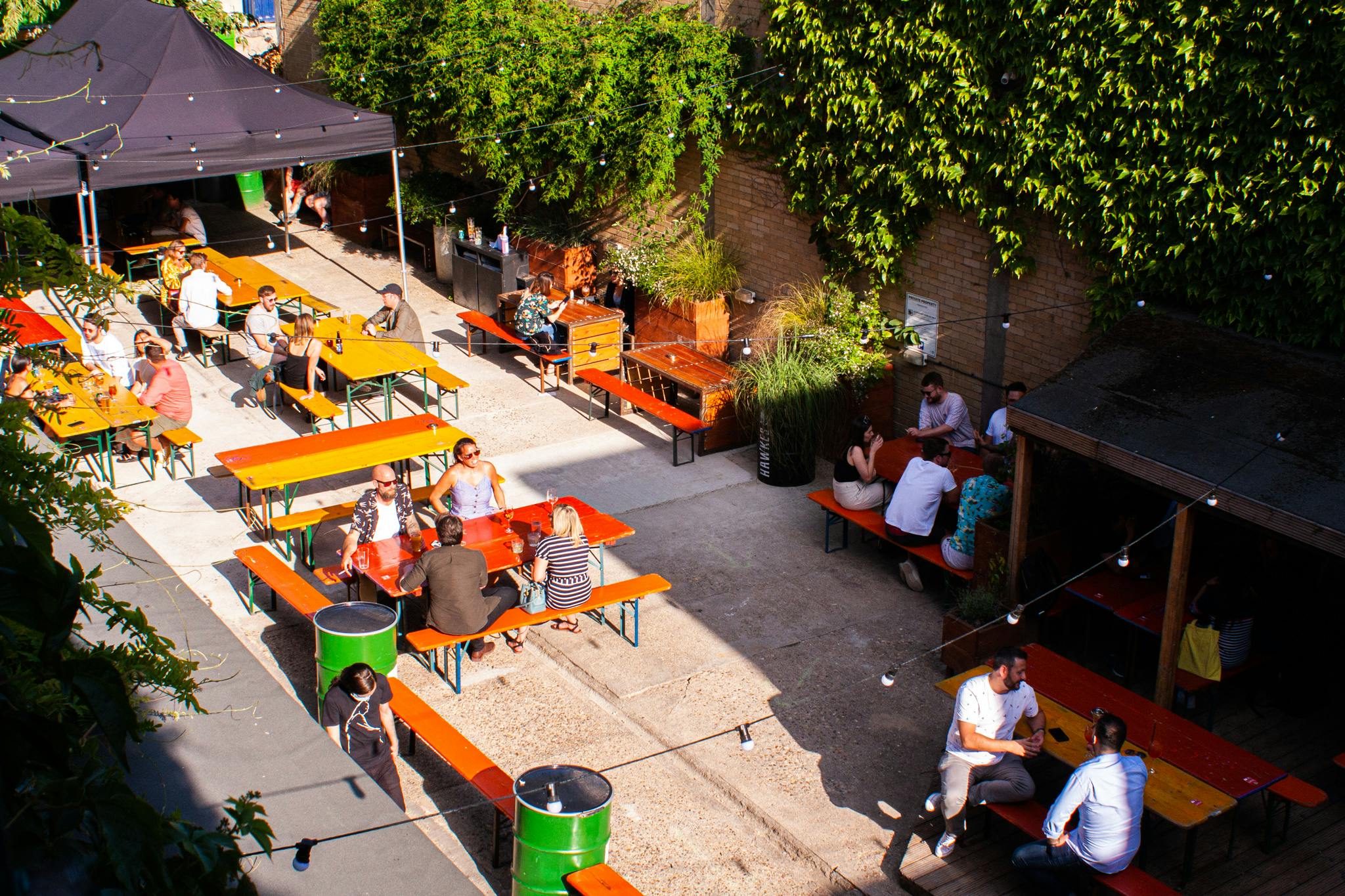 Vibrant outdoor event space with picnic tables at Strongroom Bar & Kitchen for summer parties.