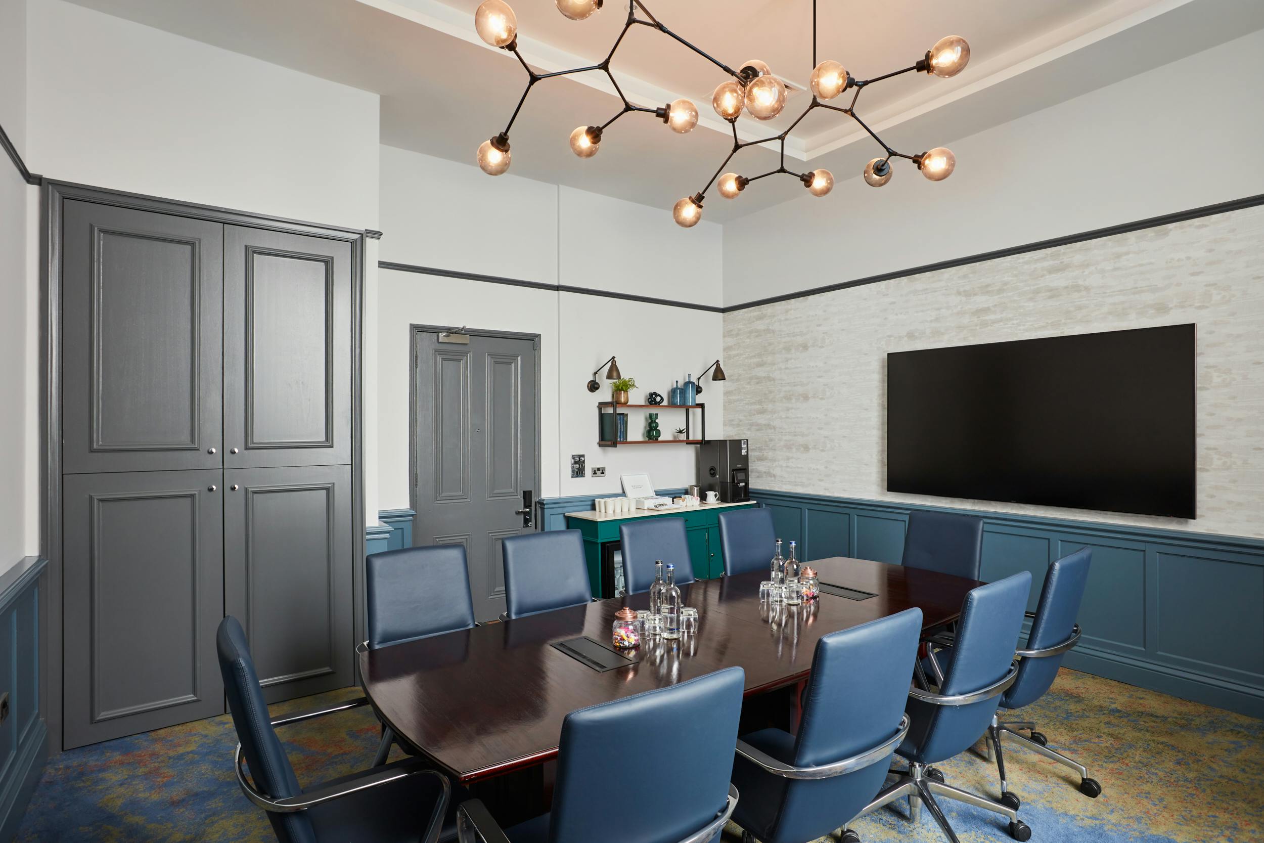 Modern Blue Boardroom with sleek table, ideal for meetings and presentations.