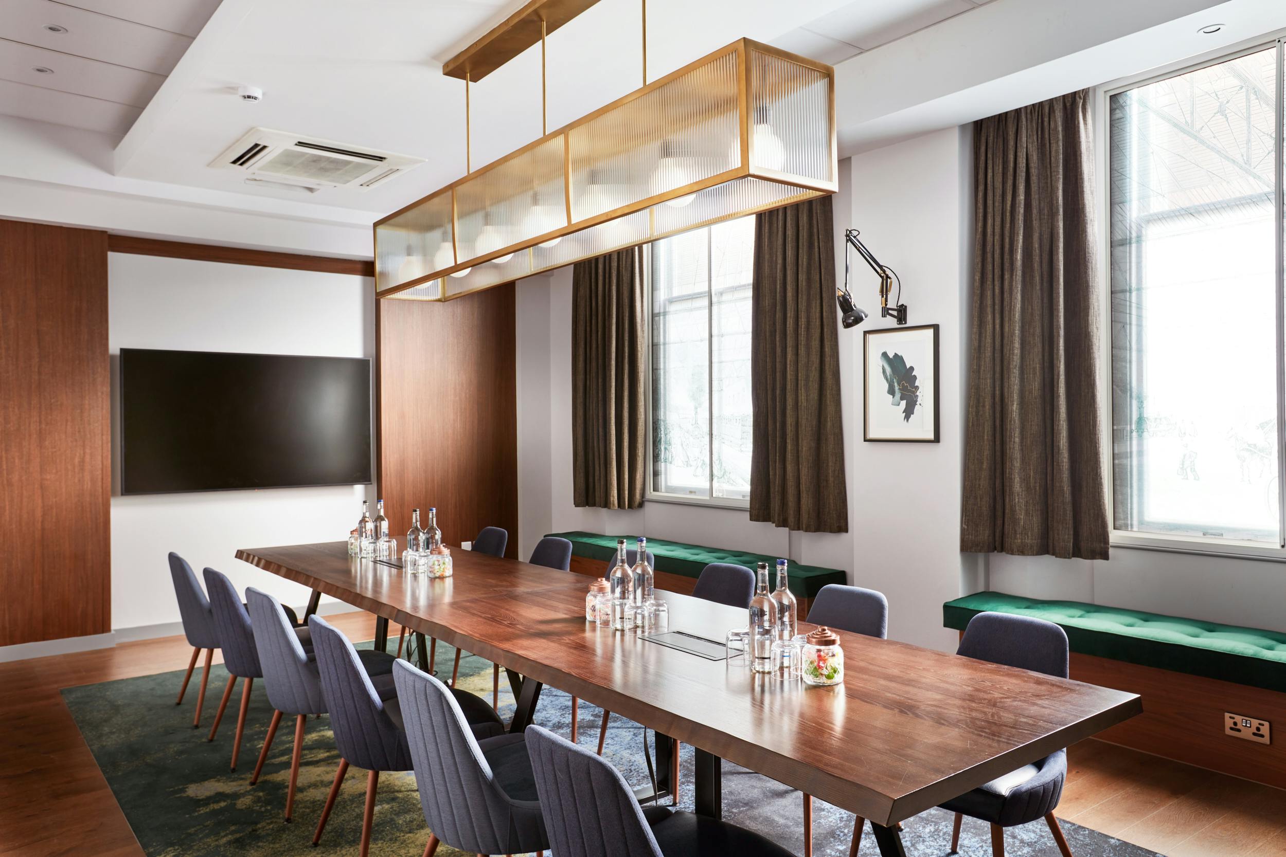 Modern meeting room with wooden table and natural light for corporate events.