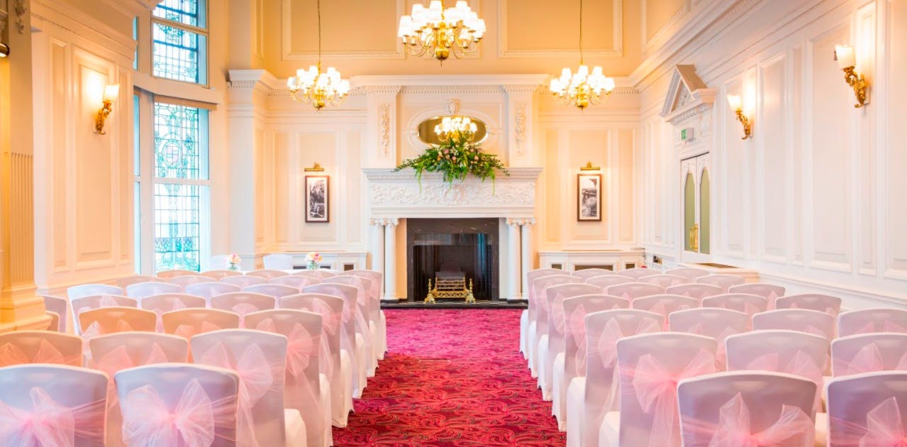 Orient Suite at Clermont Victoria, elegant wedding venue with pink sashes and fireplace.