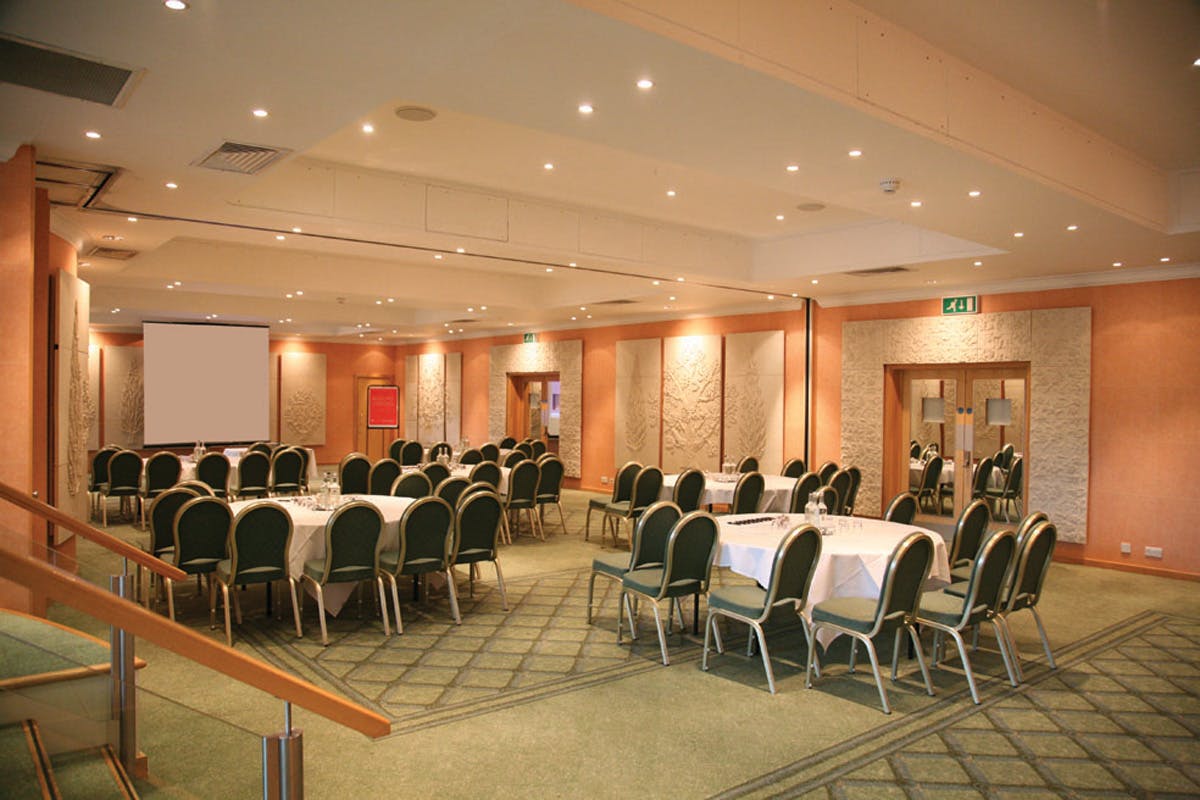 Parkland Suite at Regency Park Hotel, ideal for corporate events with round tables and green chairs.