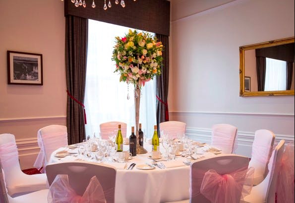 Elegant round table with floral centerpiece in The Viceroy Room, ideal for weddings and events.