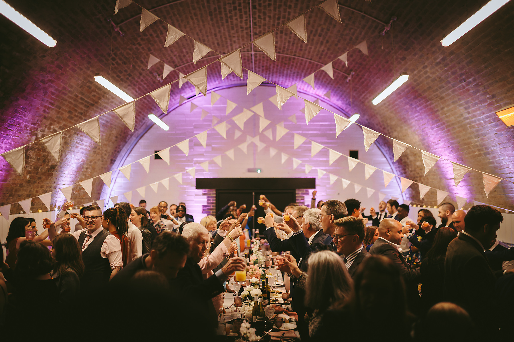 Vibrant event space at AMP Studios with guests toasting, ideal for celebrations and gatherings. - Banner