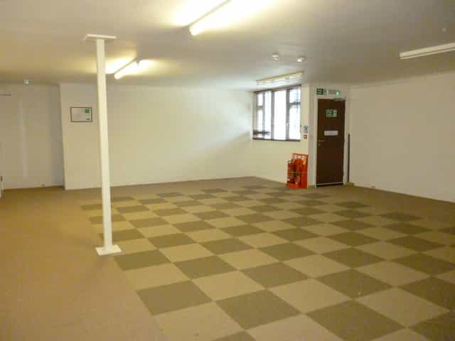Spacious empty meeting room with checkered carpet at Deanwood Barn Conference Centre.