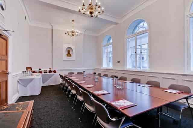 Elegant meeting room with long table, ideal for corporate events and gatherings.