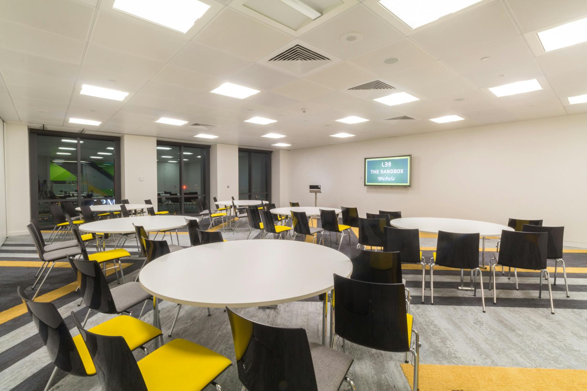 Versatile meeting space with round tables, ideal for workshops and conferences at Level39.