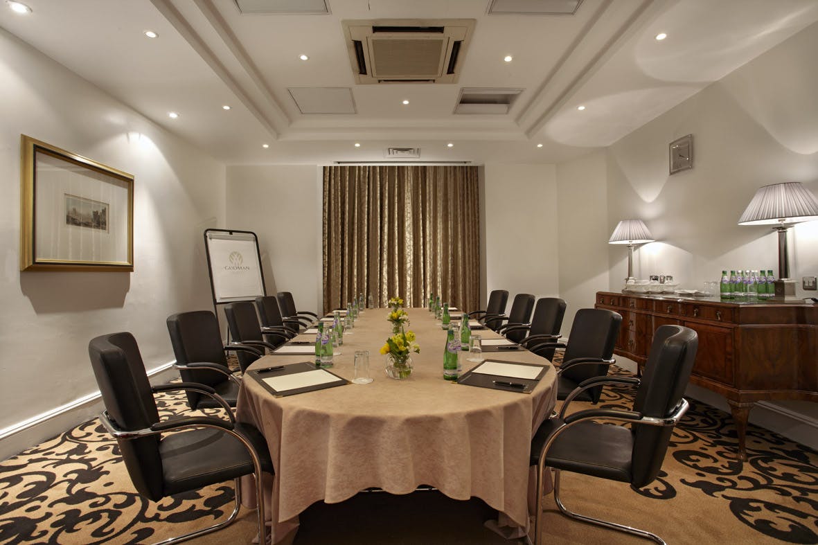 Waterloo Suite meeting room with round table, elegant decor for corporate events.