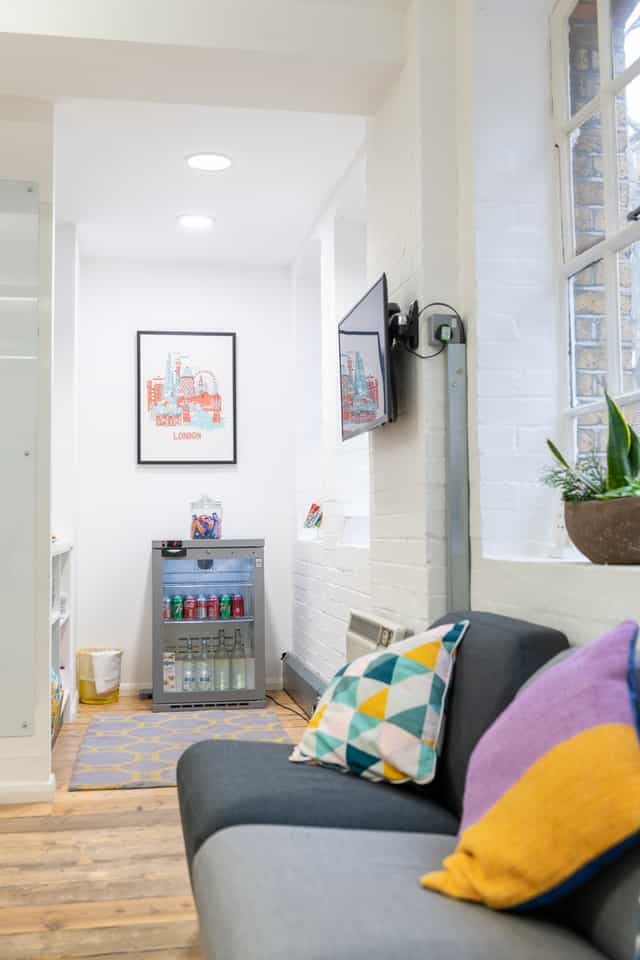 Sutherland Labs Lounge with sleek fridge, vibrant decor for events and meetings.