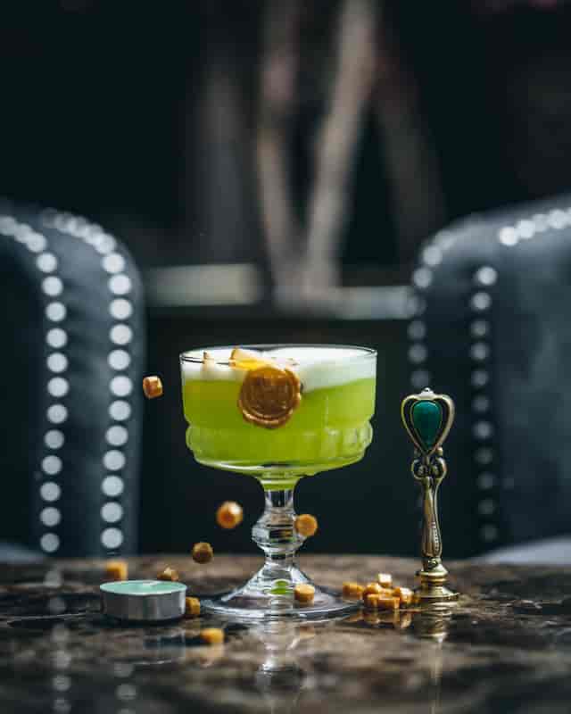 Vibrant green cocktail with foam at Karma Sanctum Soho for upscale events.