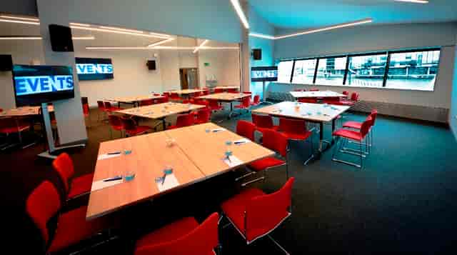 Versatile meeting space with red chairs at Imperial War Museum North for corporate events.