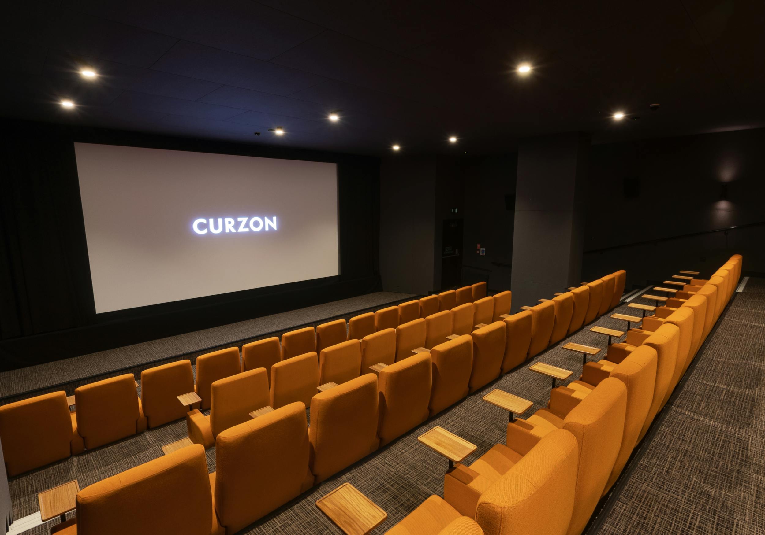 Curzon Aldgate Cinema Screen 2 with plush orange seating for private film events.