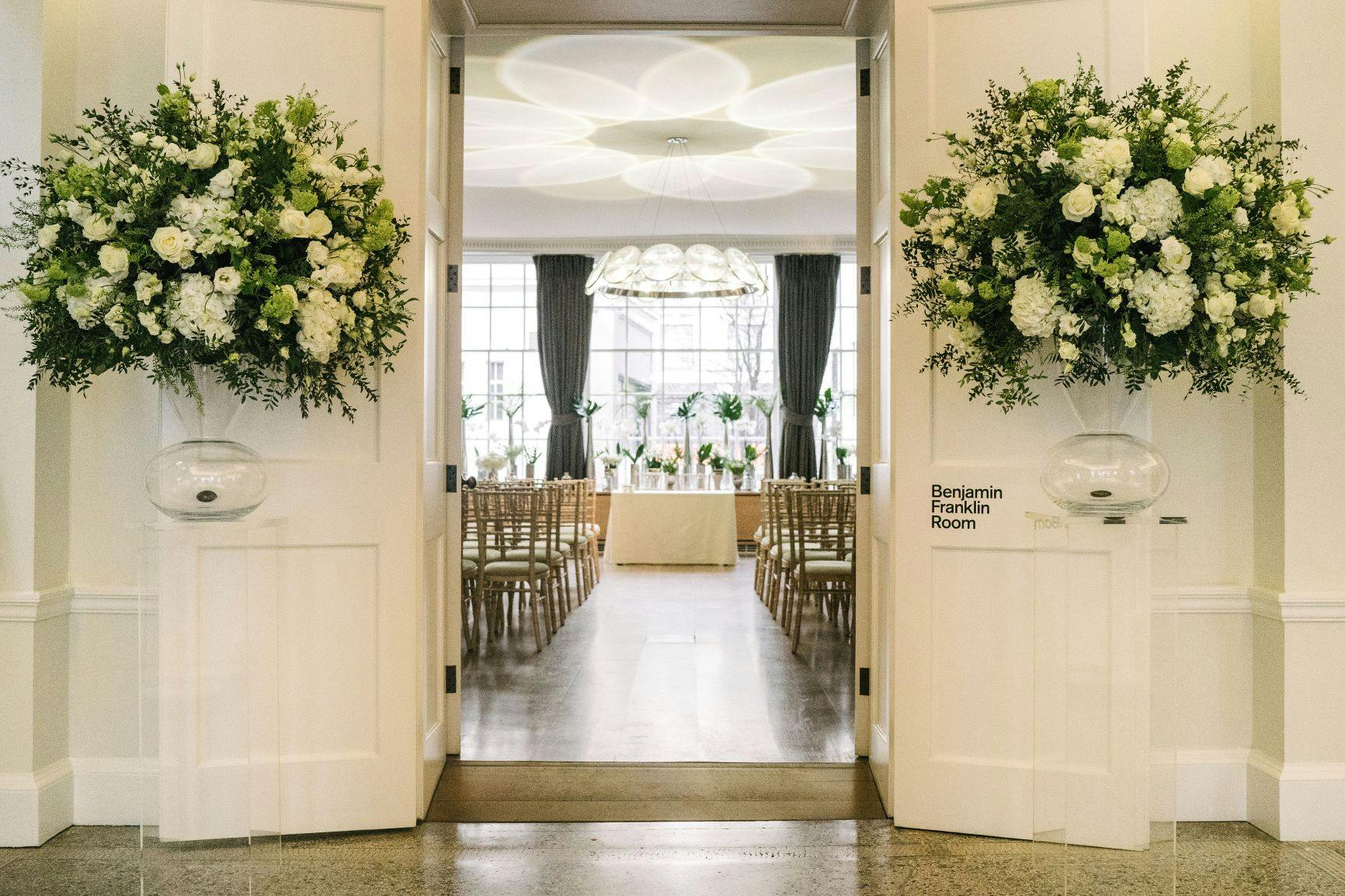 Elegant wedding venue entrance with floral arrangements at RSA House.