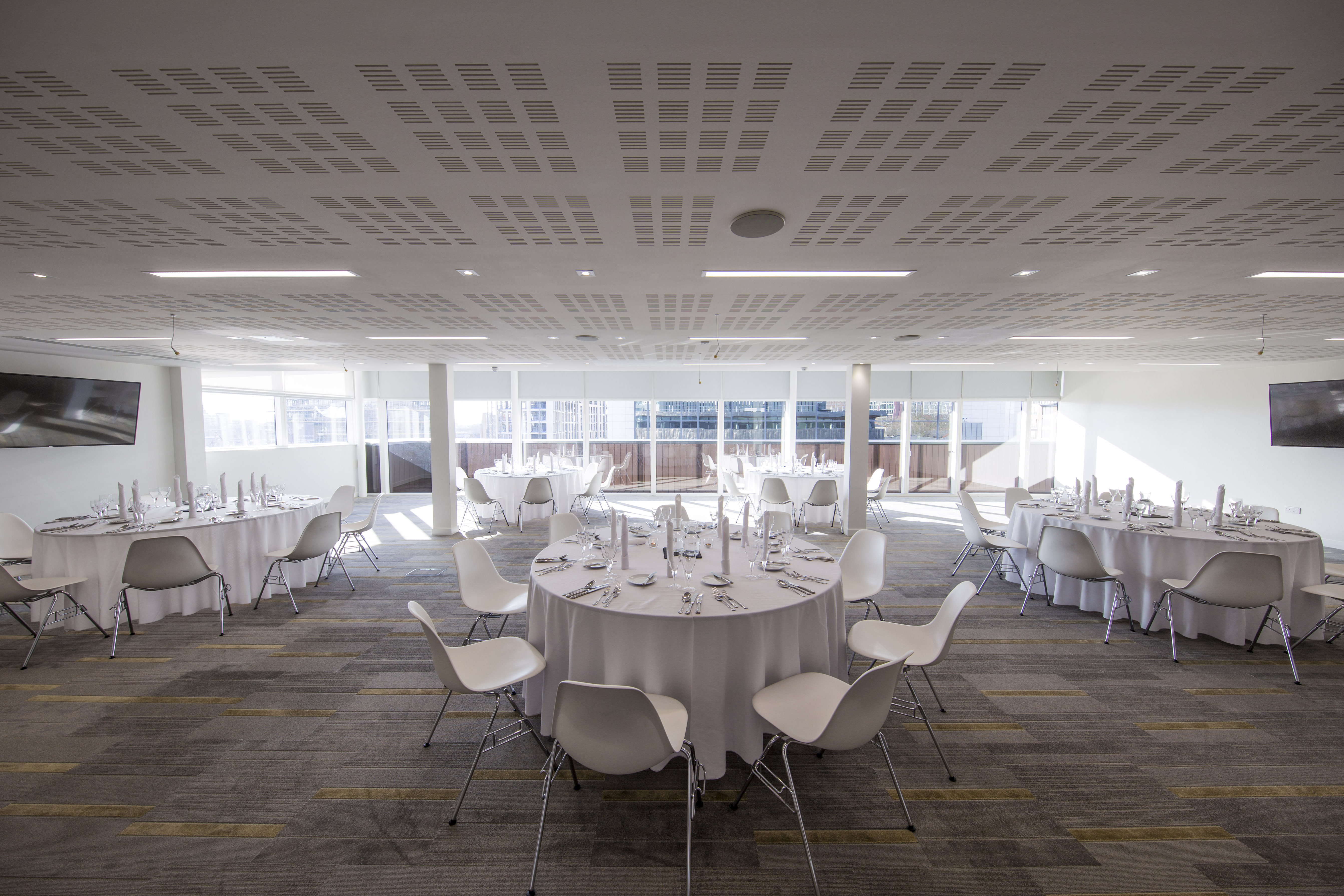 Modern event space with round tables, ideal for corporate gatherings and networking. - Banner