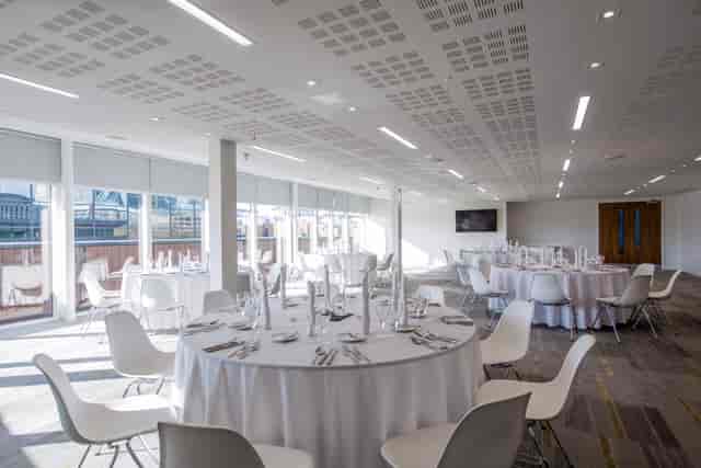 Modern event space with round tables, ideal for meetings and social gatherings.