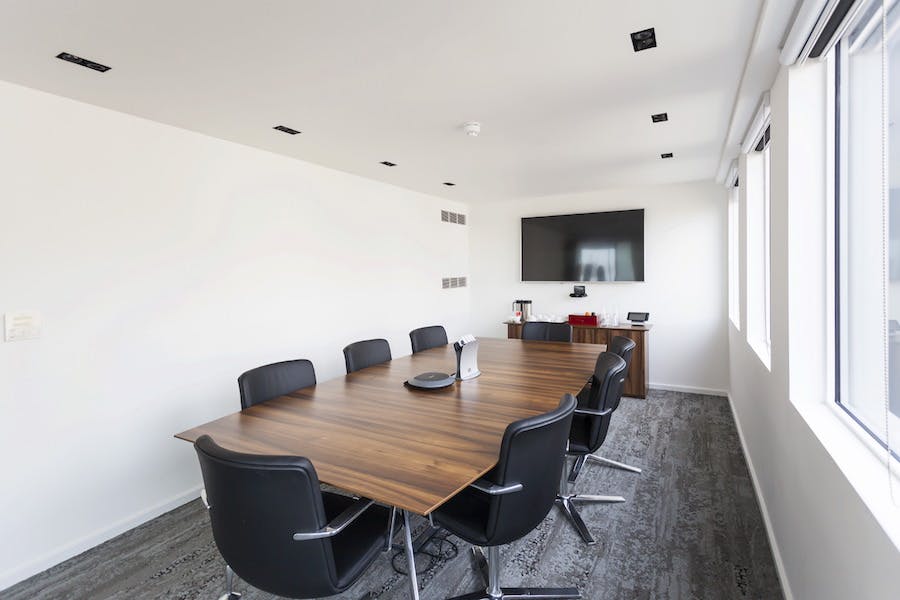 Modern Boardroom 2 at Us&Co Monument, featuring a sleek wooden table for professional meetings.