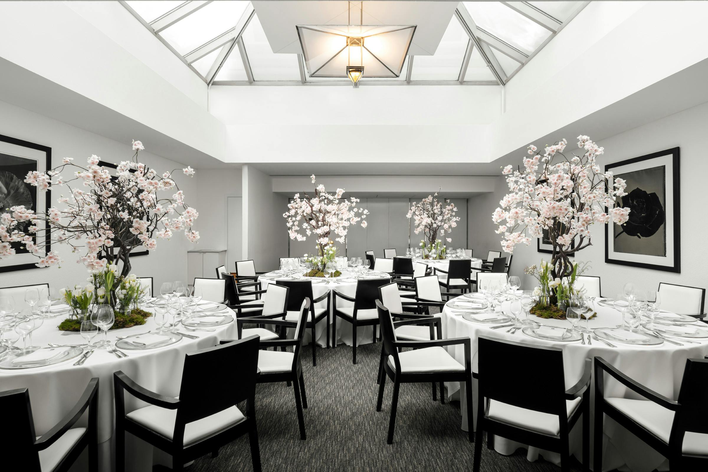 Elegant event space with round tables and floral decor at COMO Metropolitan London.