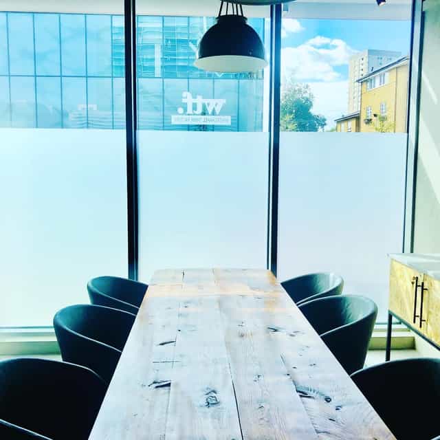 Modern meeting space at Holiday Inn Whitechapel with wooden table and natural light.