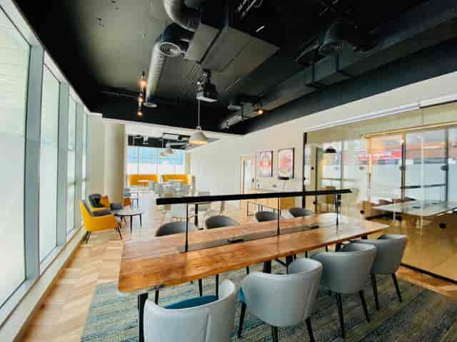 Modern meeting space at Holiday Inn Whitechapel with large wooden table for collaboration.