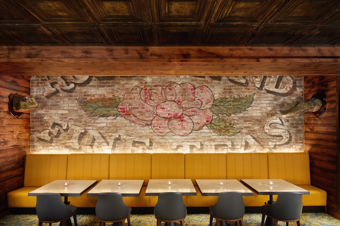 Stylish OXBO Restaurant event space with floral mural, ideal for networking and gatherings.